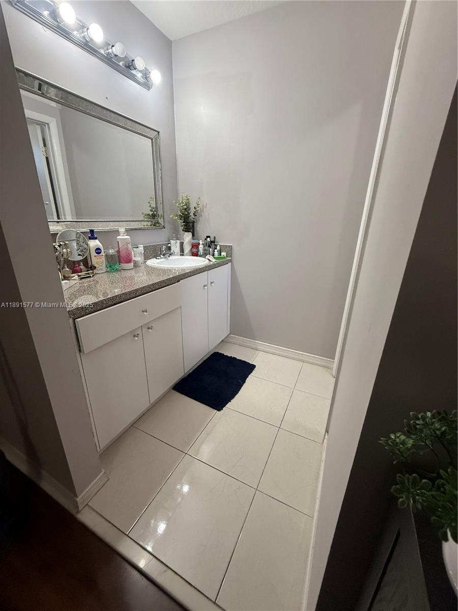7145 Northwest 173rd Drive, Unit 1106 Hialeah, FL 33015 - Photo 16 of 17 a bathroom with a sink and a mirror