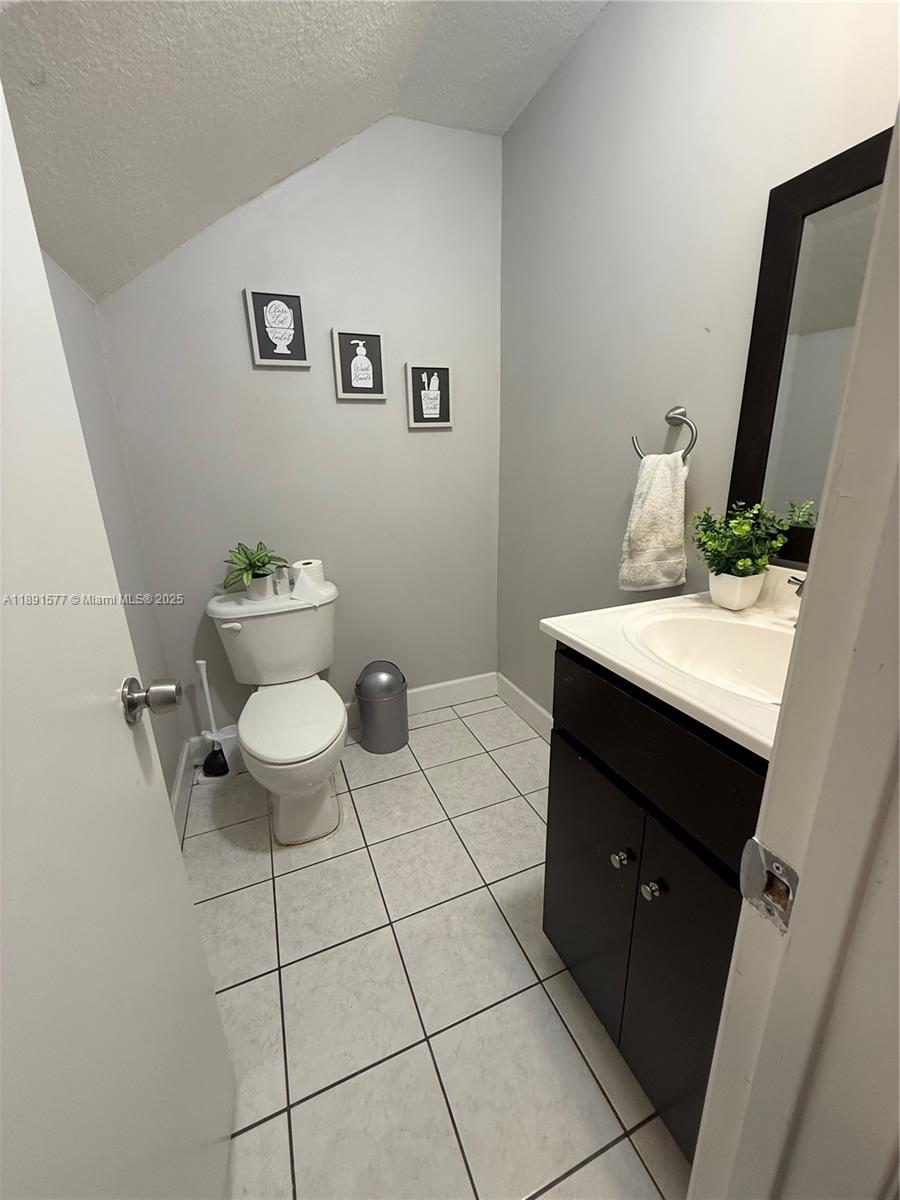 7145 Northwest 173rd Drive, Unit 1106 Hialeah, FL 33015 - Photo 3 of 17 a bathroom with a sink toilet and mirror