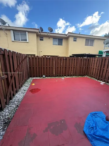 a view of a backyard with a barbeque grill and wooden floor