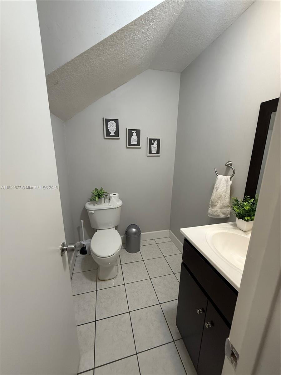7145 Northwest 173rd Drive, Unit 1106 Hialeah, FL 33015 - Photo 7 of 17 a bathroom with a sink a toilet and a mirror