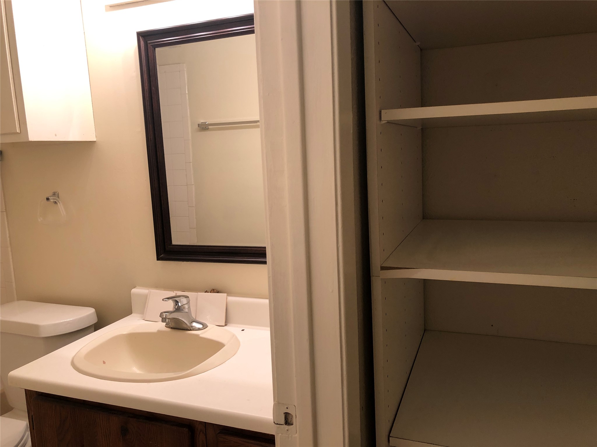 11510 Walnut Ridge Drive, Unit B Austin, TX 78753 - Photo 11 of 18 A functional bathroom with a wood vanity sits adjacent to built-in hallway linen shelving.