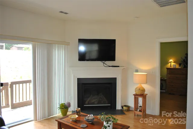 a living room with furniture a fireplace and a flat screen tv