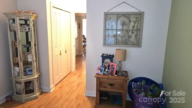 a view of a hallway with wooden floor and a dining table