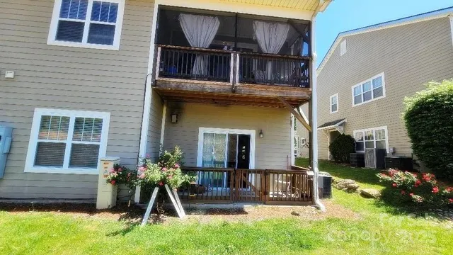 a view of a white house with a large windows and flower plants