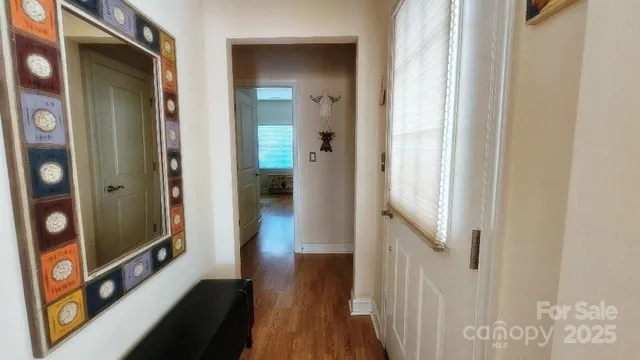 a view of a hallway with wooden floor and staircase