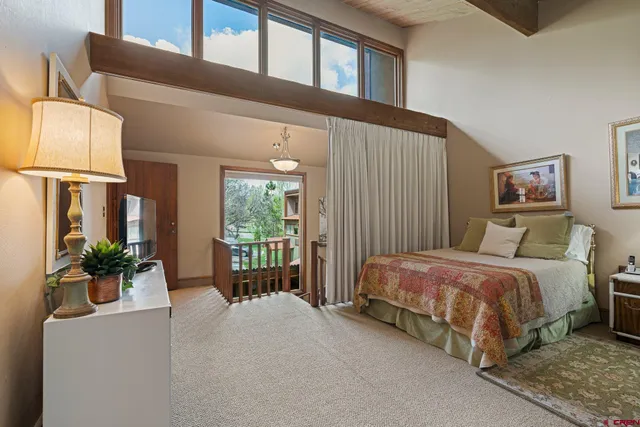 a spacious bedroom with a bed and large windows