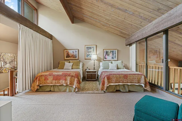 a spacious bedroom with two beds and a chandelier