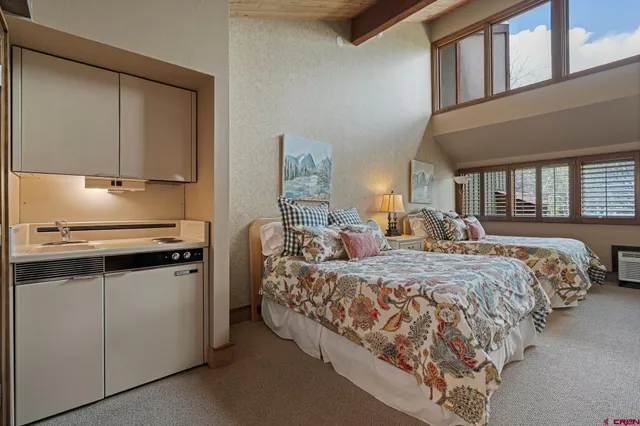 a spacious bedroom with two beds and a dresser