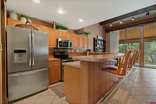 a kitchen with granite countertop a refrigerator and a stove top oven