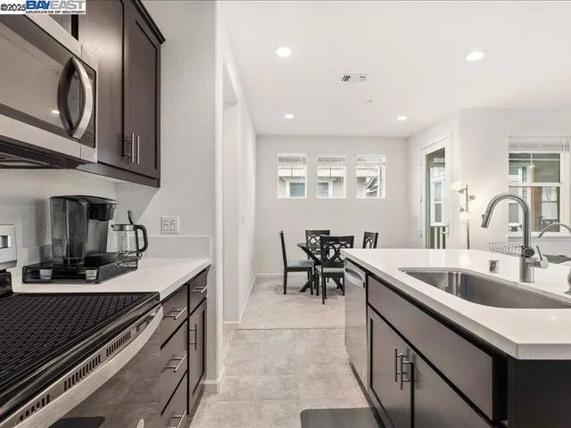 a kitchen with stainless steel appliances granite countertop a refrigerator a stove a sink and a oven