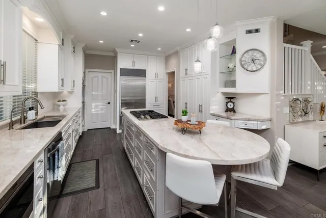 a kitchen with stainless steel appliances a table chairs stove and cabinets