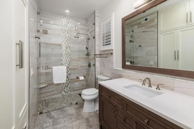 a bathroom with a sink a toilet and shower