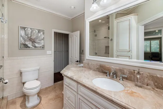 a bathroom with a granite countertop toilet a sink and a mirror