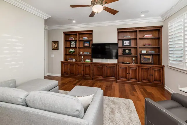 a living room with furniture cabinets and a flat screen tv