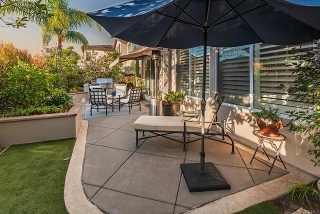 a patio with a table and chairs under an umbrella