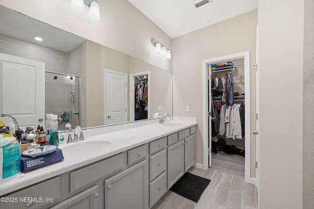 a en suite bathroom with a double vanity sink and a mirror