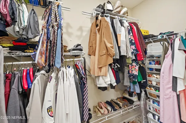 a view of walk in closet with clothes