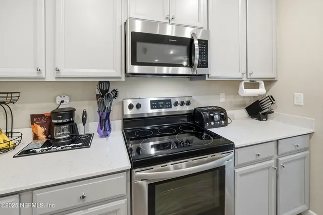 a kitchen with microwave cabinets and stove top oven