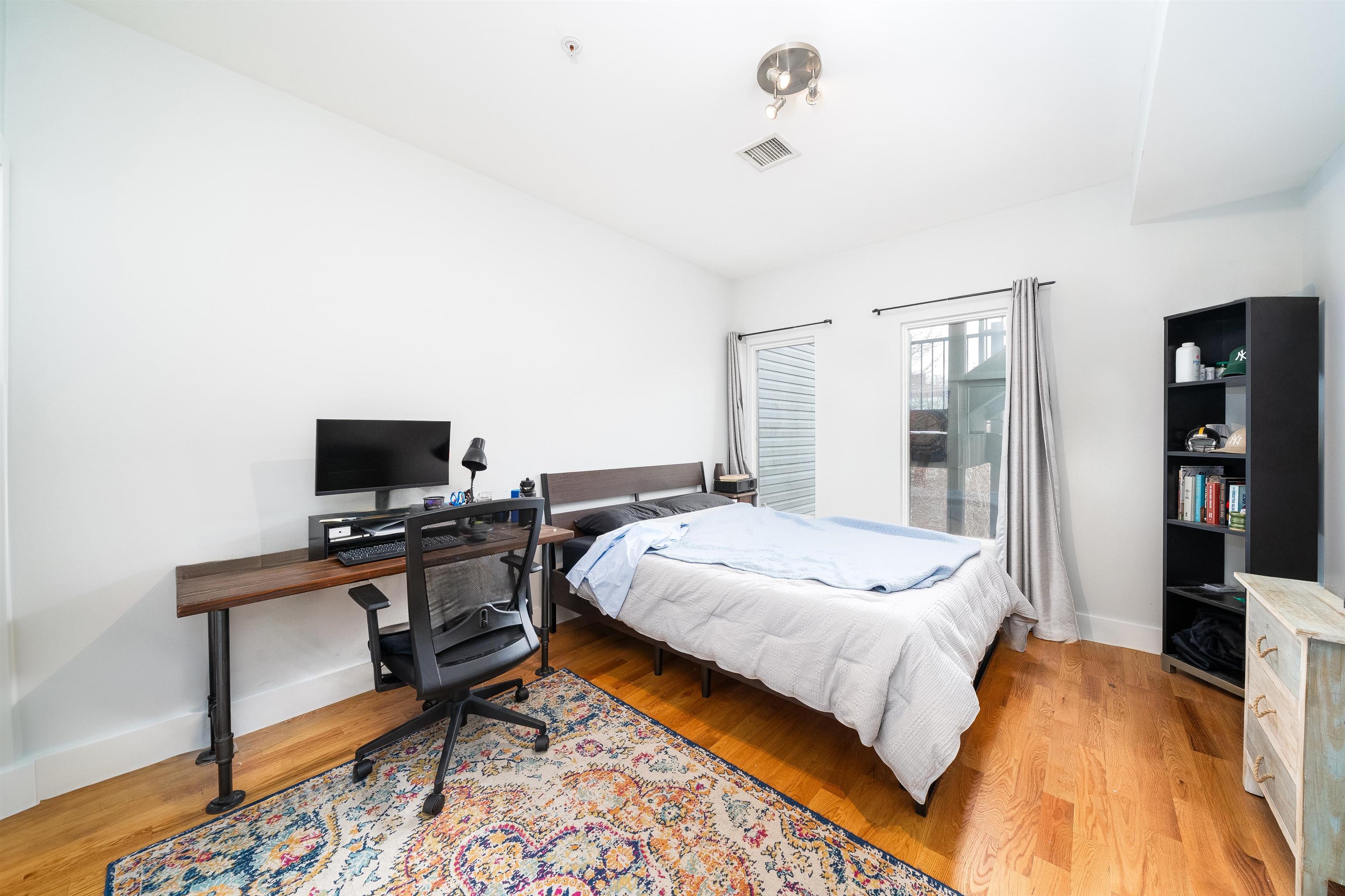516 Monroe Street, Unit 3 Hoboken, NJ 07030 - Photo 12 of 13 a bedroom with a bed and a flat screen tv