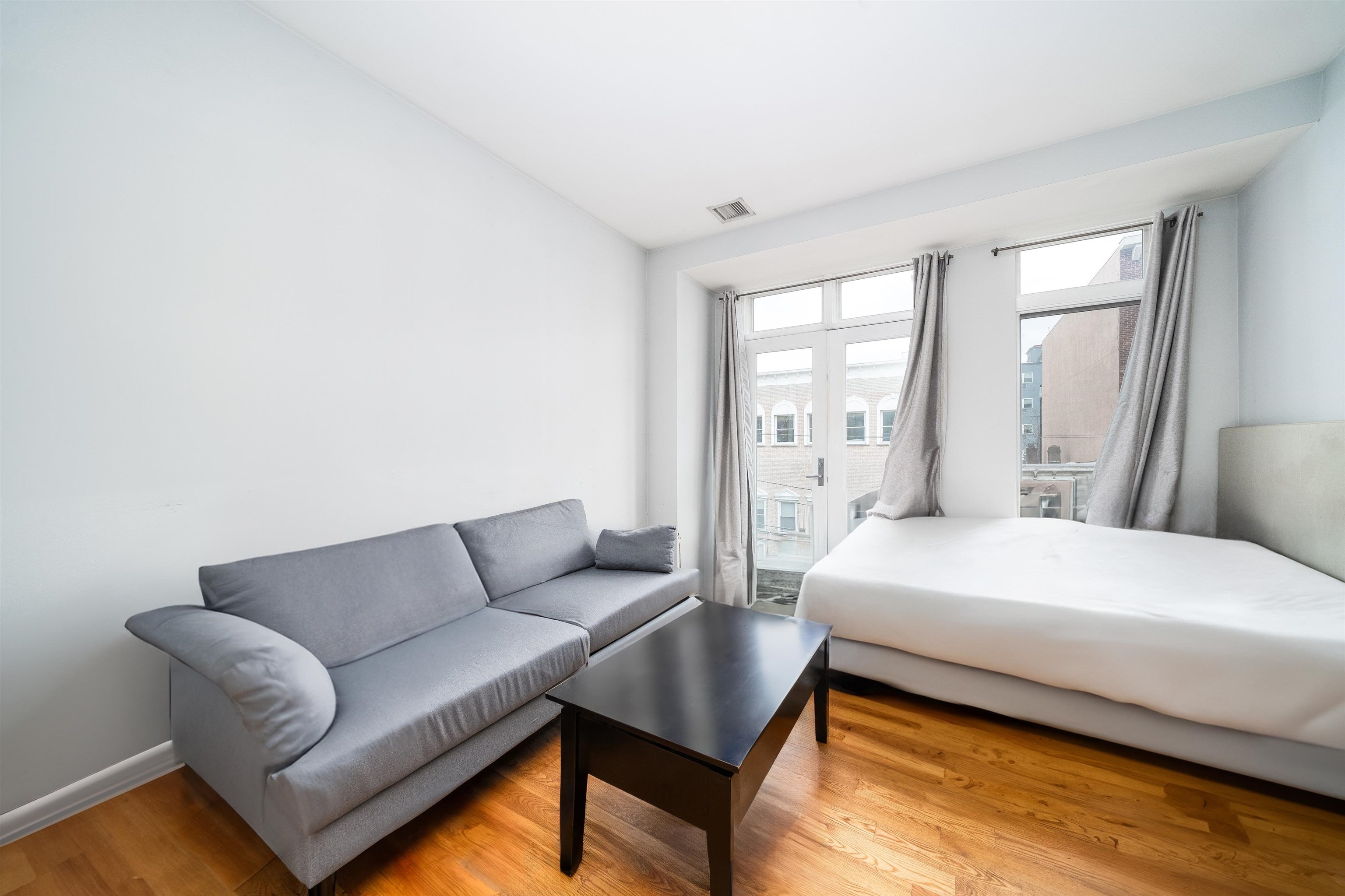 516 Monroe Street, Unit 3 Hoboken, NJ 07030 - Photo 4 of 13 a bedroom with a bed couch and window