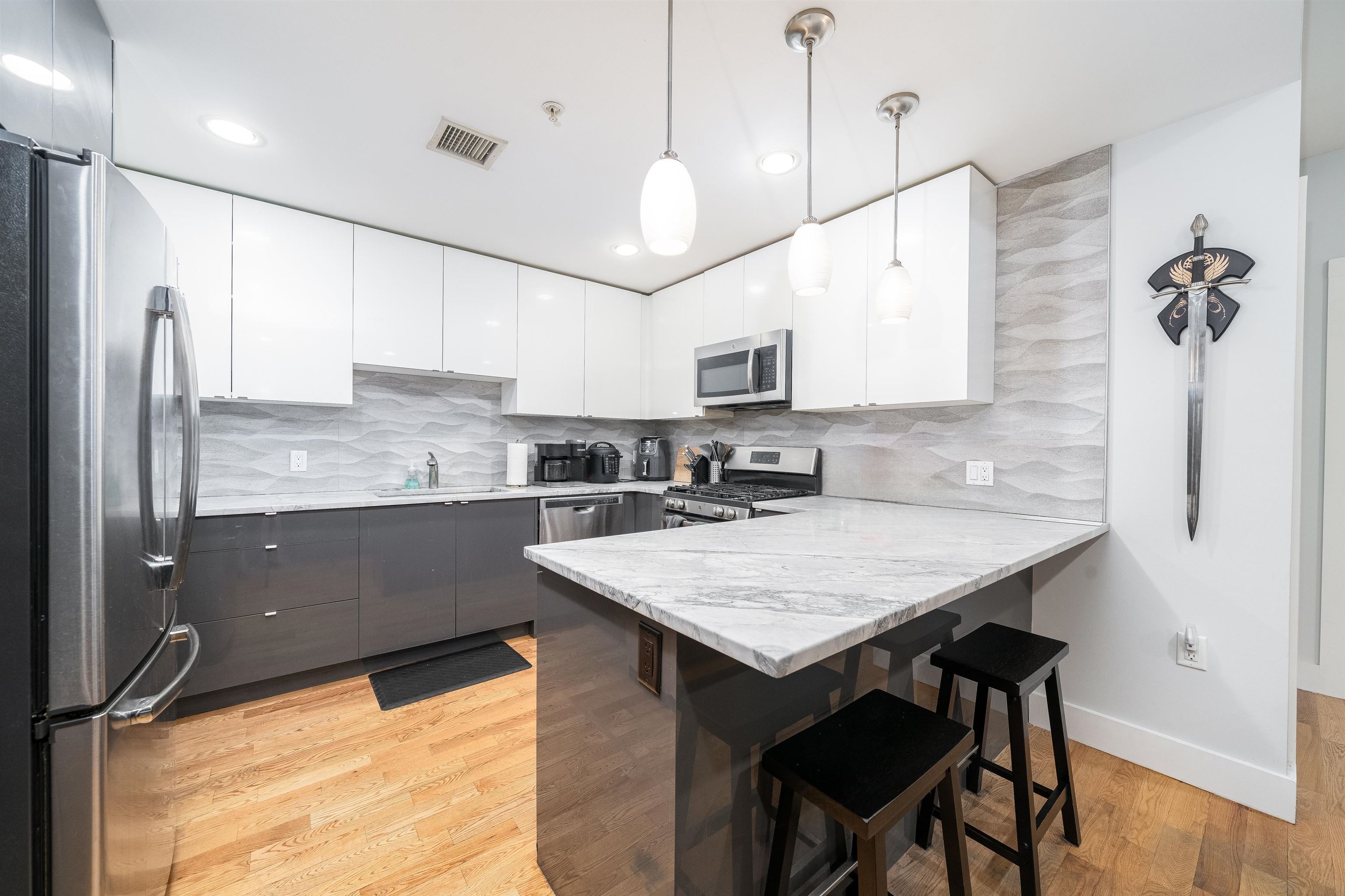 516 Monroe Street, Unit 3 Hoboken, NJ 07030 - Photo 10 of 13 a kitchen with stainless steel appliances granite countertop a sink refrigerator and microwave
