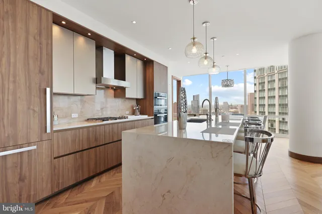 a kitchen with stainless steel appliances granite countertop a sink dishwasher a refrigerator white cabinets and wooden floor