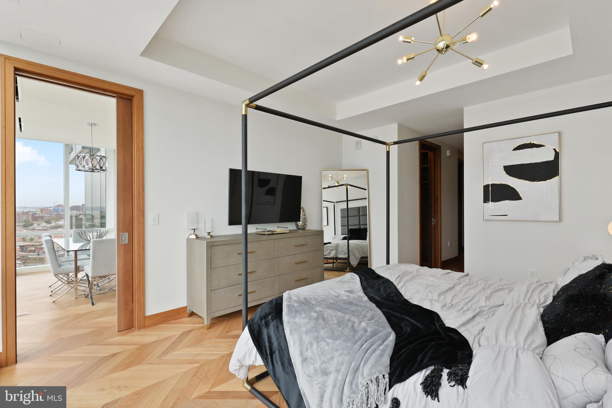 300 International Drive, Unit 2403 Baltimore, MD 21202 - Photo 18 of 36 a bedroom with a bed and glass door