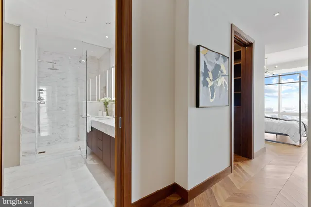 a view of a bathroom with double vanity and glass door