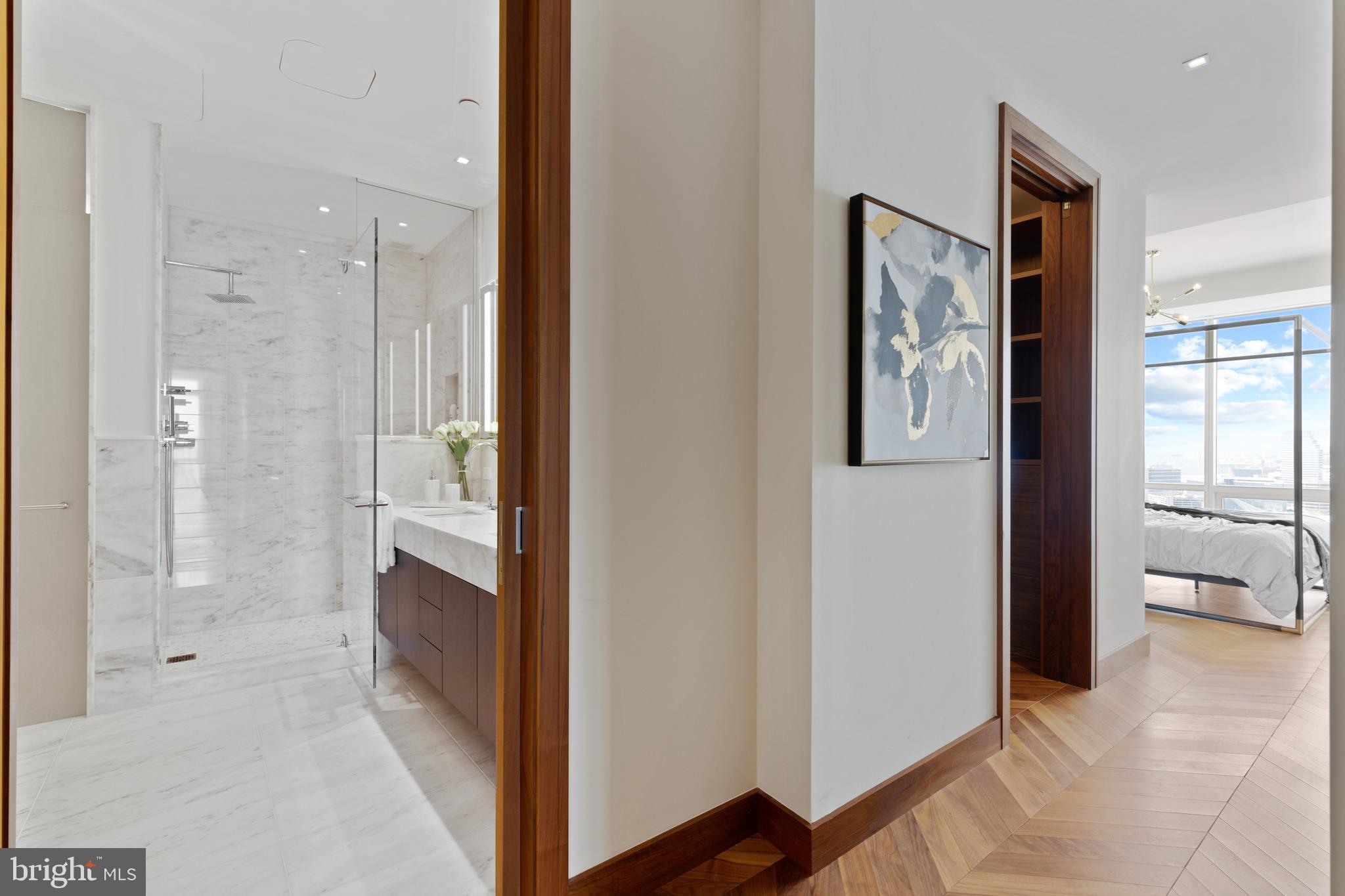 300 International Drive, Unit 2403 Baltimore, MD 21202 - Photo 20 of 36 a view of a bathroom with double vanity and glass door