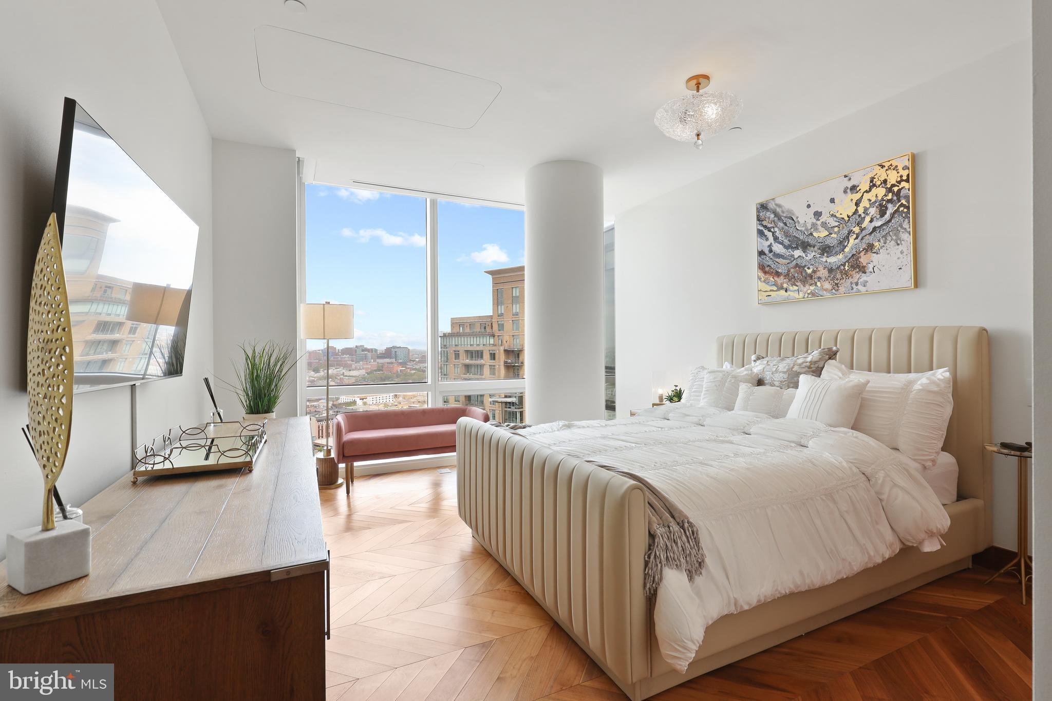 300 International Drive, Unit 2403 Baltimore, MD 21202 - Photo 29 of 36 a bedroom with a large bed and a large window