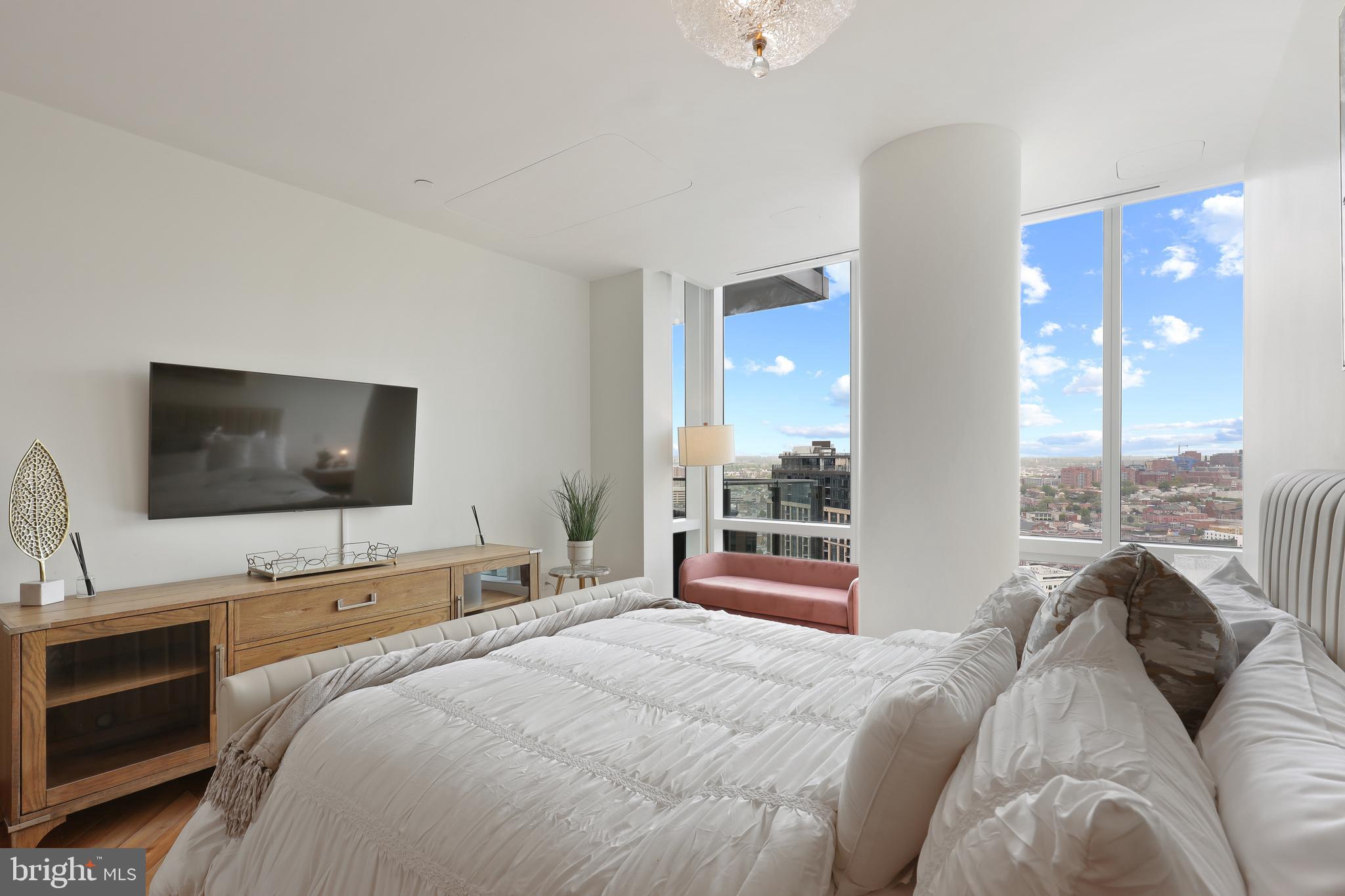 300 International Drive, Unit 2403 Baltimore, MD 21202 - Photo 31 of 36 a bedroom with a bed and a flat screen tv