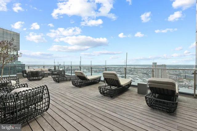 a dining hall with stainless steel appliances granite countertop a stove a sink dishwasher and white cabinets with wooden floor