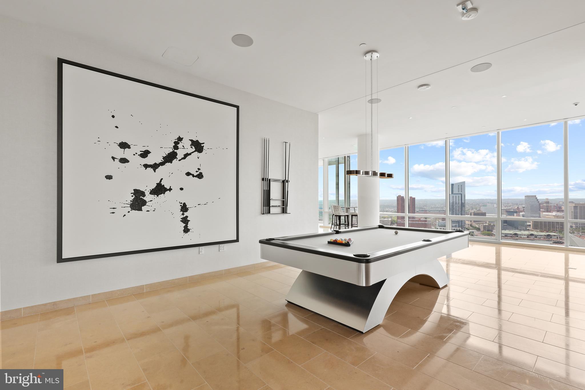 300 International Drive, Unit 2403 Baltimore, MD 21202 - Photo 34 of 36 a dining hall with stainless steel appliances granite countertop a stove a sink dishwasher and white cabinets with wooden floor