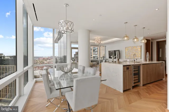 a living room with kitchen island granite countertop furniture a large window and stainless steel appliances