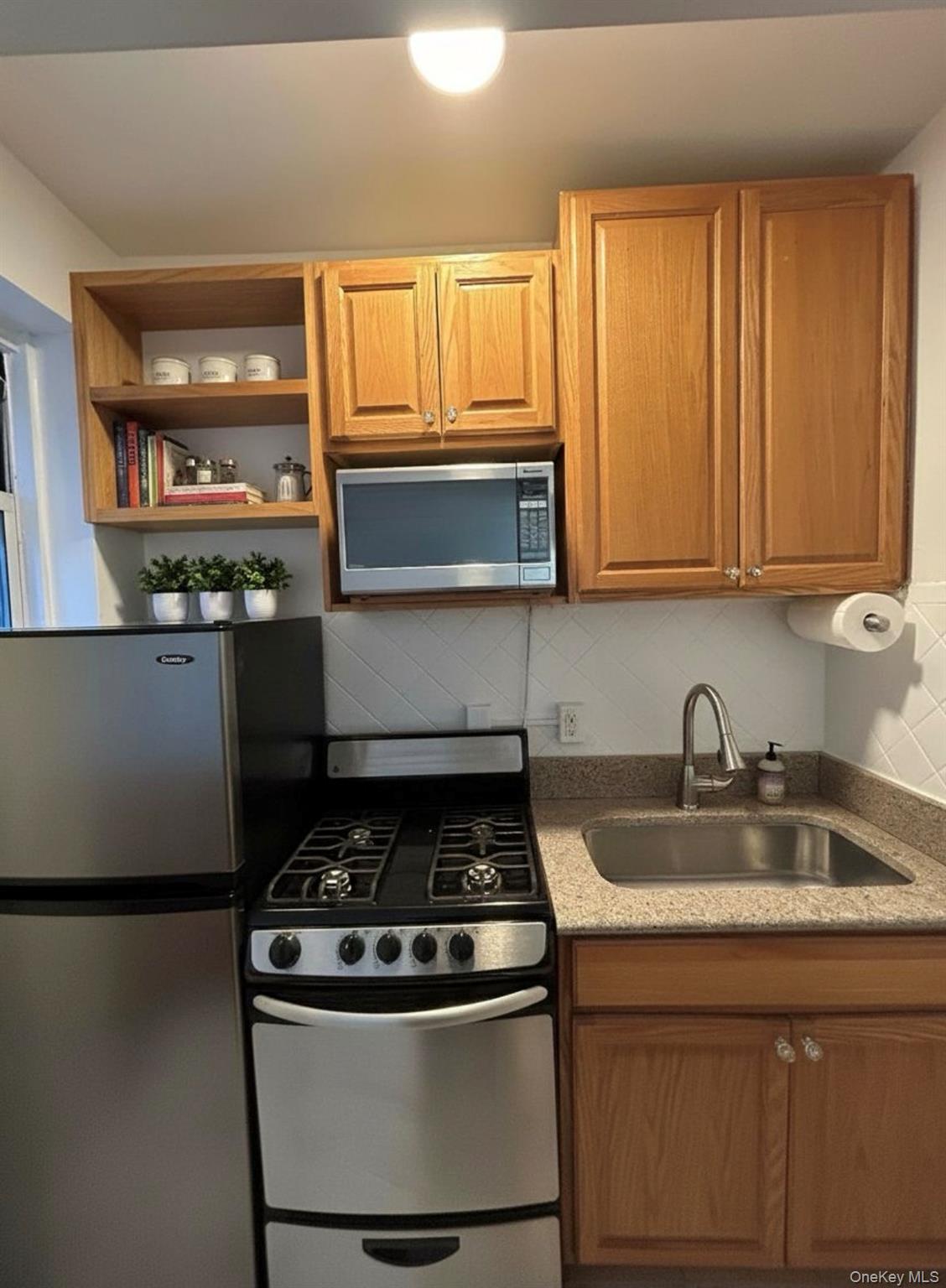210 Pelham Road, Unit 5P New Rochelle, NY 10805 - Photo 2 of 25 a kitchen with a stove and a microwave