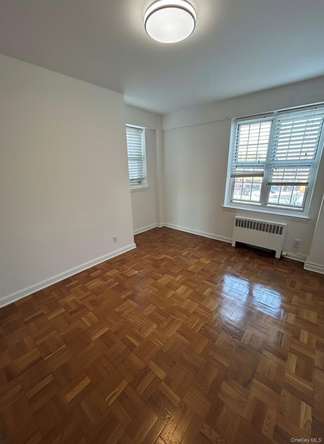 210 Pelham Road, Unit 5P New Rochelle, NY 10805 - Photo 8 of 25 wooden floor in an empty room with a window