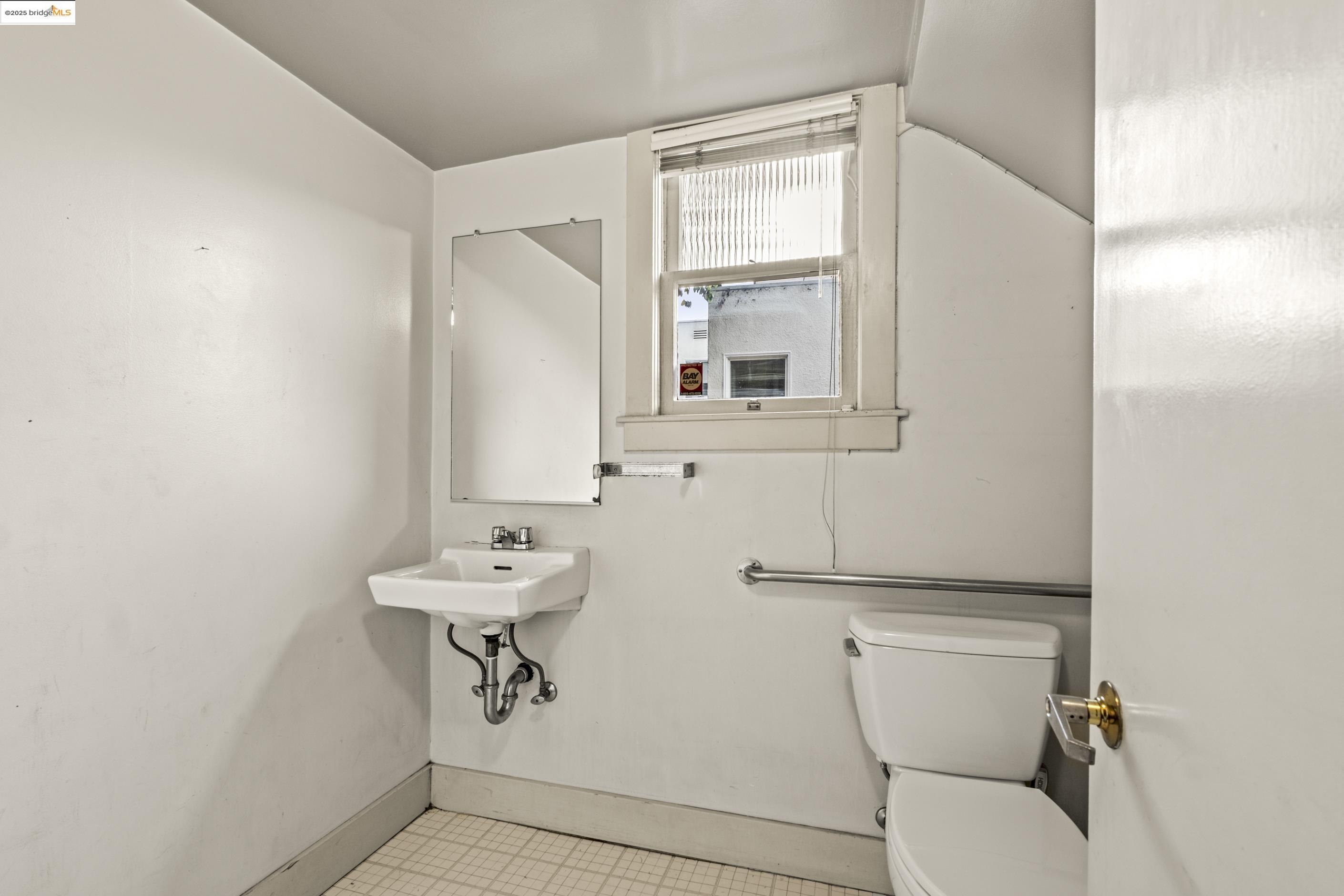 3050 Shattuck Avenue Berkeley, CA 94705 - Photo 4 of 41 a bathroom with a toilet a sink and mirror