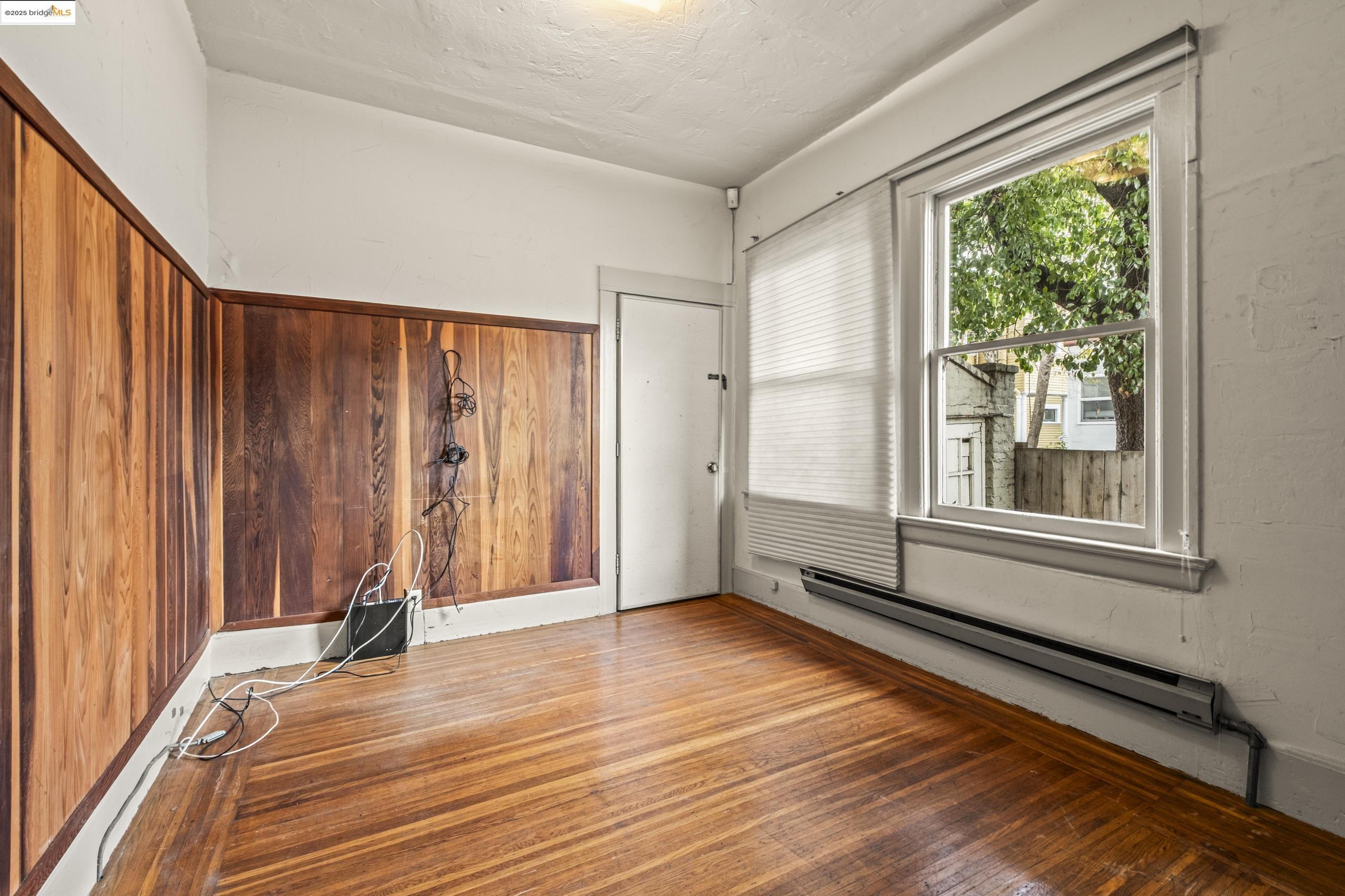 3050 Shattuck Avenue Berkeley, CA 94705 - Photo 5 of 41 a view of an empty room with wooden floor and a window