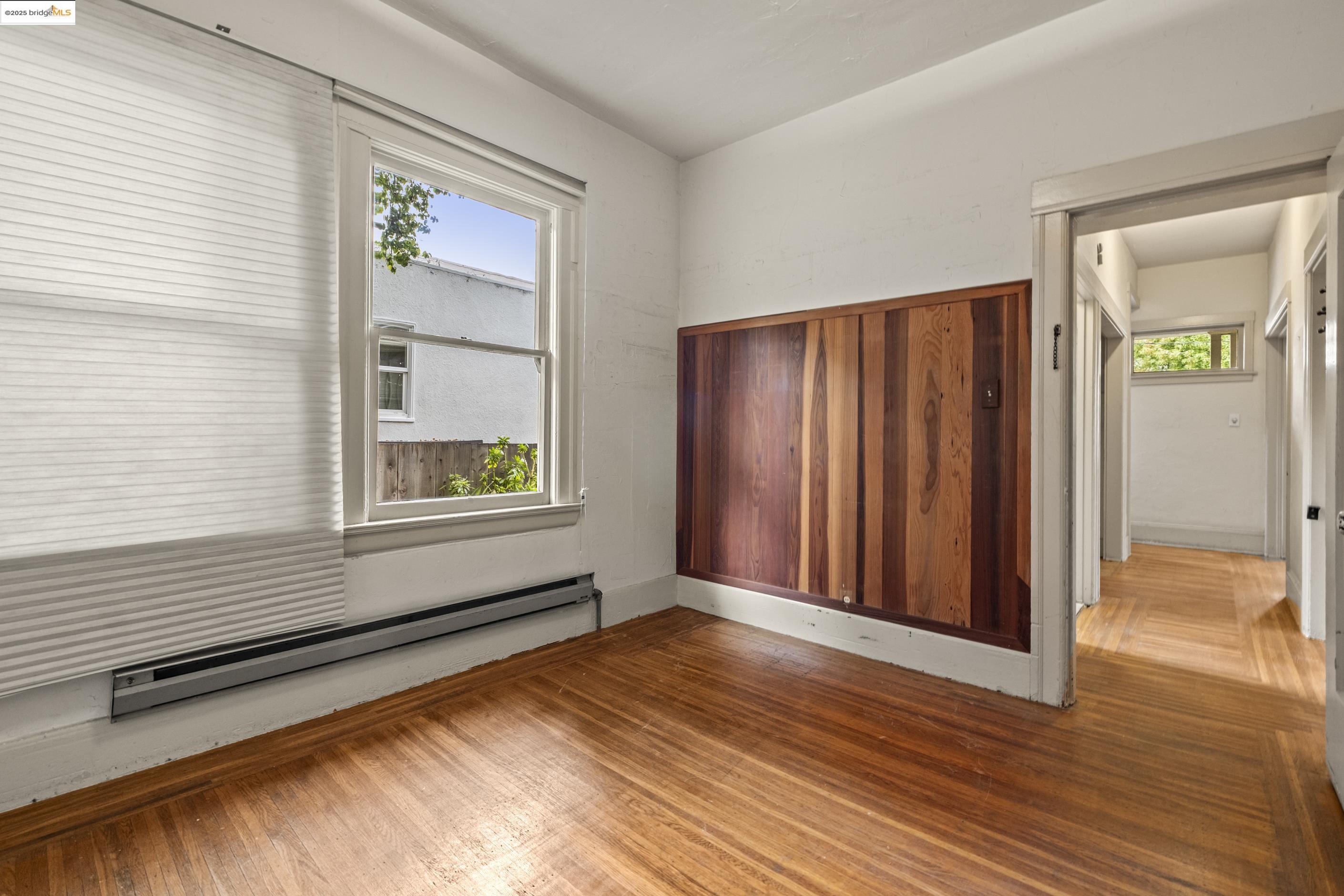 3050 Shattuck Avenue Berkeley, CA 94705 - Photo 7 of 41 a view of an empty room with wooden floor and a window