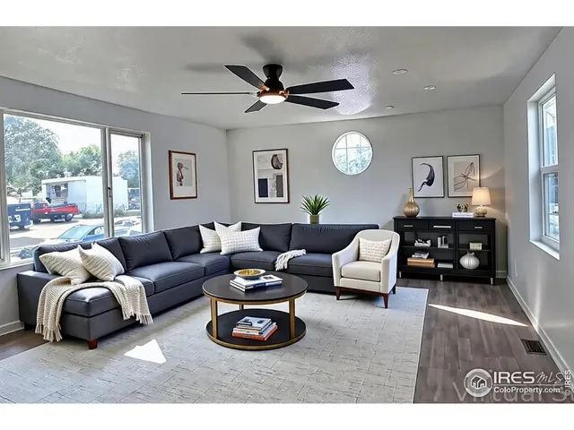 a living room with furniture a large window and a rug