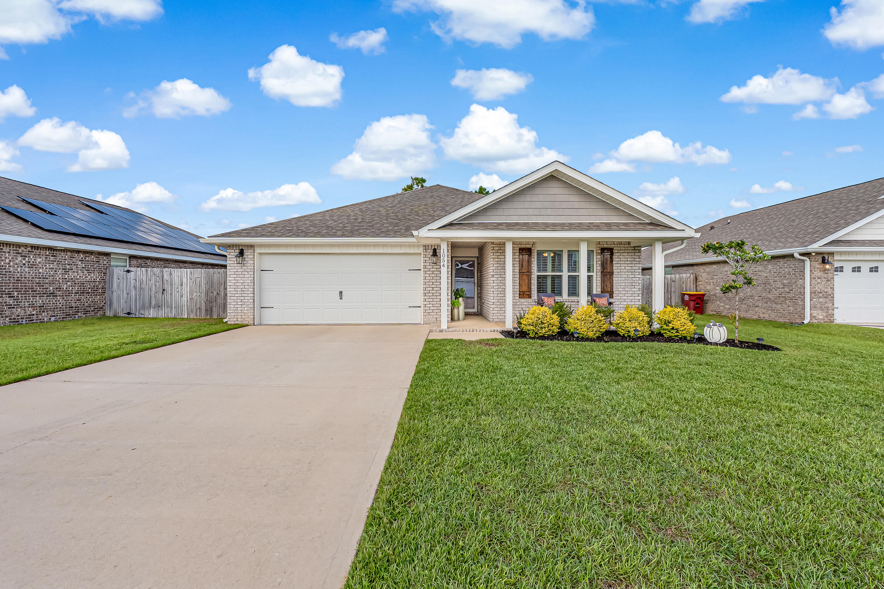 a view of a house with a big yard and large tree