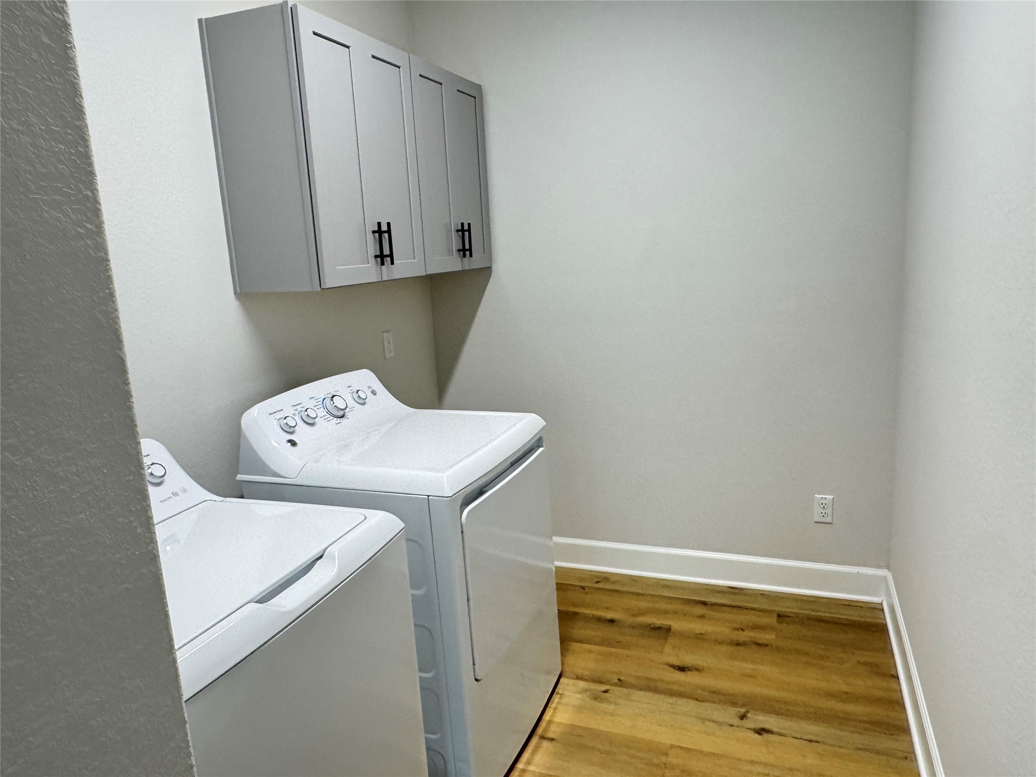 3000 Chisholm Trail Road, Unit 63 Round Rock, TX 78681 - Photo 31 of 31 Clothes washing area with independent washer and dryer, baseboards, cabinet space, and light wood-style flooring