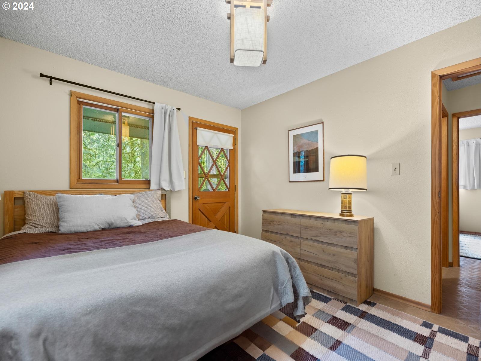 69125 East Vine Maple Drive Rhododendron, OR 97049 - Photo 23 of 41 a bedroom with a bed and a dresser next to a window