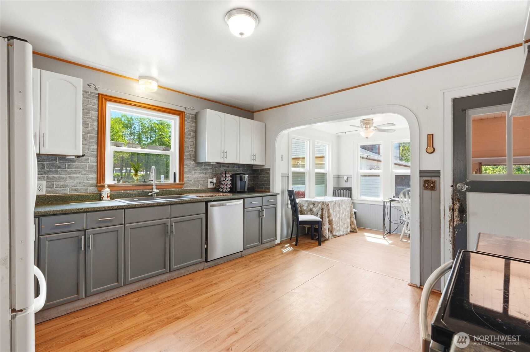 21716 State Rte 530 Northeast Arlington, WA 98223 - Photo 3 of 38 a large kitchen with kitchen island a large window cabinets a sink and stainless steel appliances