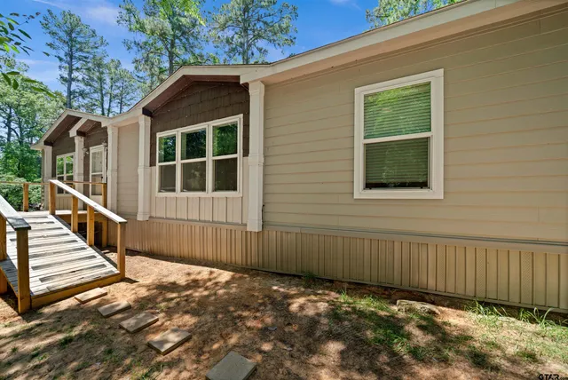 a view of a house with stairs and wooden fence