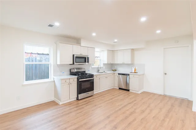 a kitchen with granite countertop a stove top oven sink and cabinets