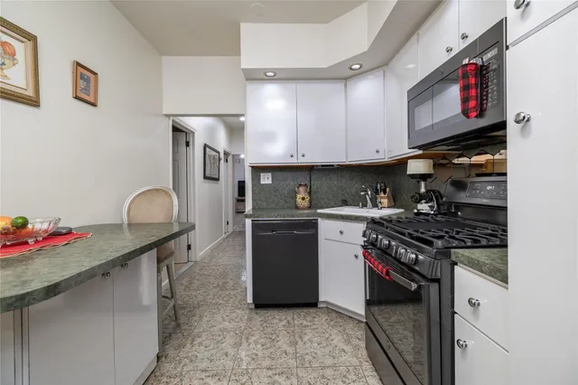 a kitchen with granite countertop a stove and cabinets