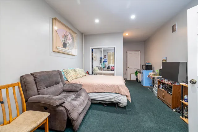 a spacious bedroom with a bed a couch and a flat screen tv