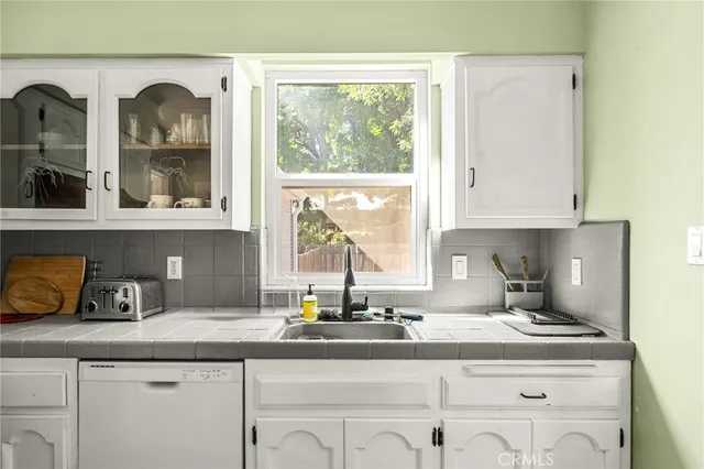 a kitchen with stainless steel appliances white cabinets and a refrigerator