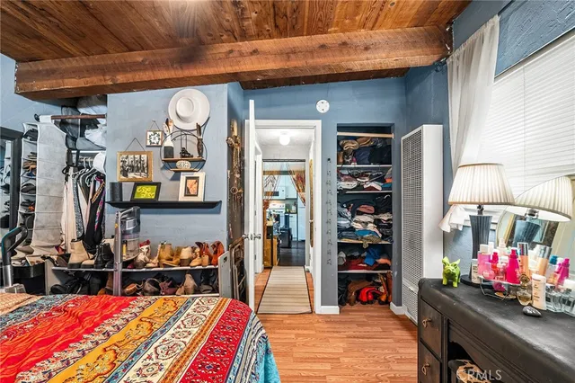 a kitchen with stainless steel appliances kitchen island granite countertop a refrigerator a stove a sink dishwasher and white cabinets with wooden floor